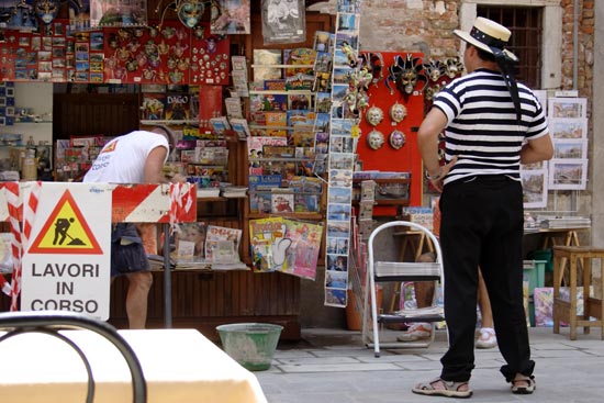 A gondolier watches a worker