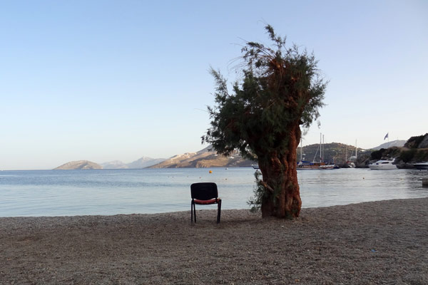 Enlig stol i strandkanten