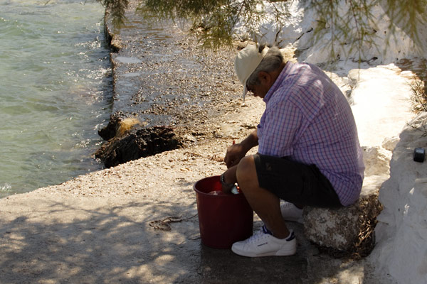 Man cleaning fish in Leros